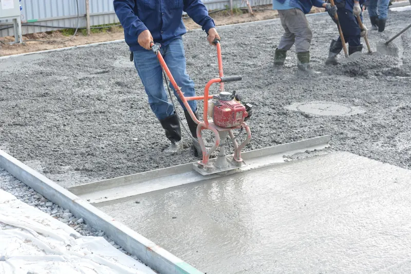 Equipo de obreros nivelando concreto recién vaciado