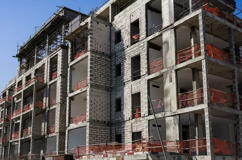 Edificio de apartamentos en construcción con andamios y malla de seguridad