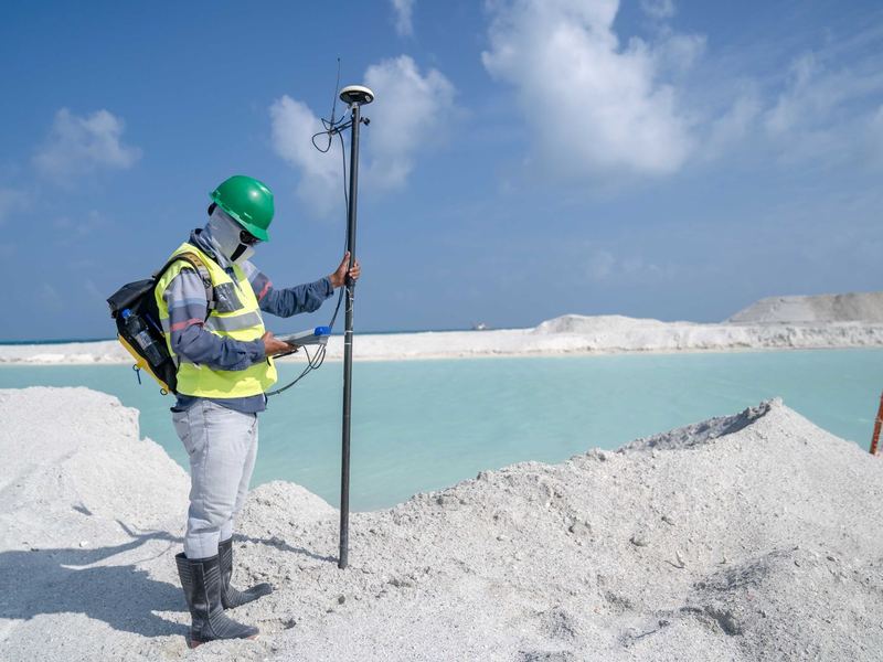 Agrimensor con receptor GPS midiendo cerca de la costa