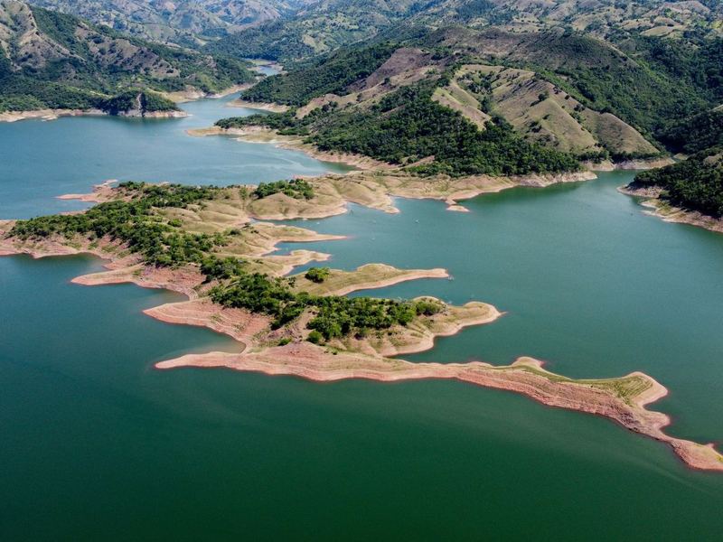 Vista aérea de un embalse entre lomas verdes en Monción, República Dominicana