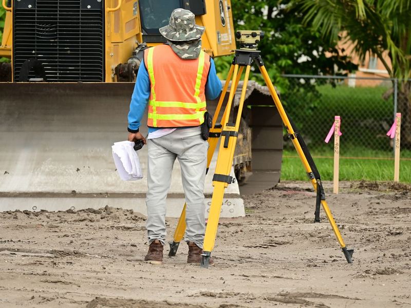 Agrimensor con estación total en un terreno en preparación