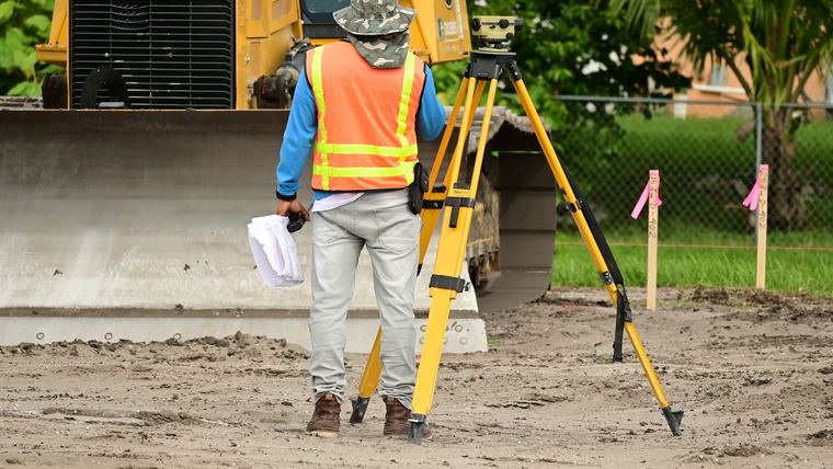 Agrimensor con estación total en un terreno en preparación