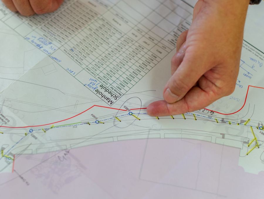 Manos revisando un plano técnico de una propiedad