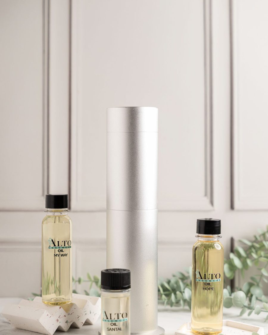 Difusor Alto Essences junto a frascos de aceite aromático y ramas de eucalipto sobre mármol