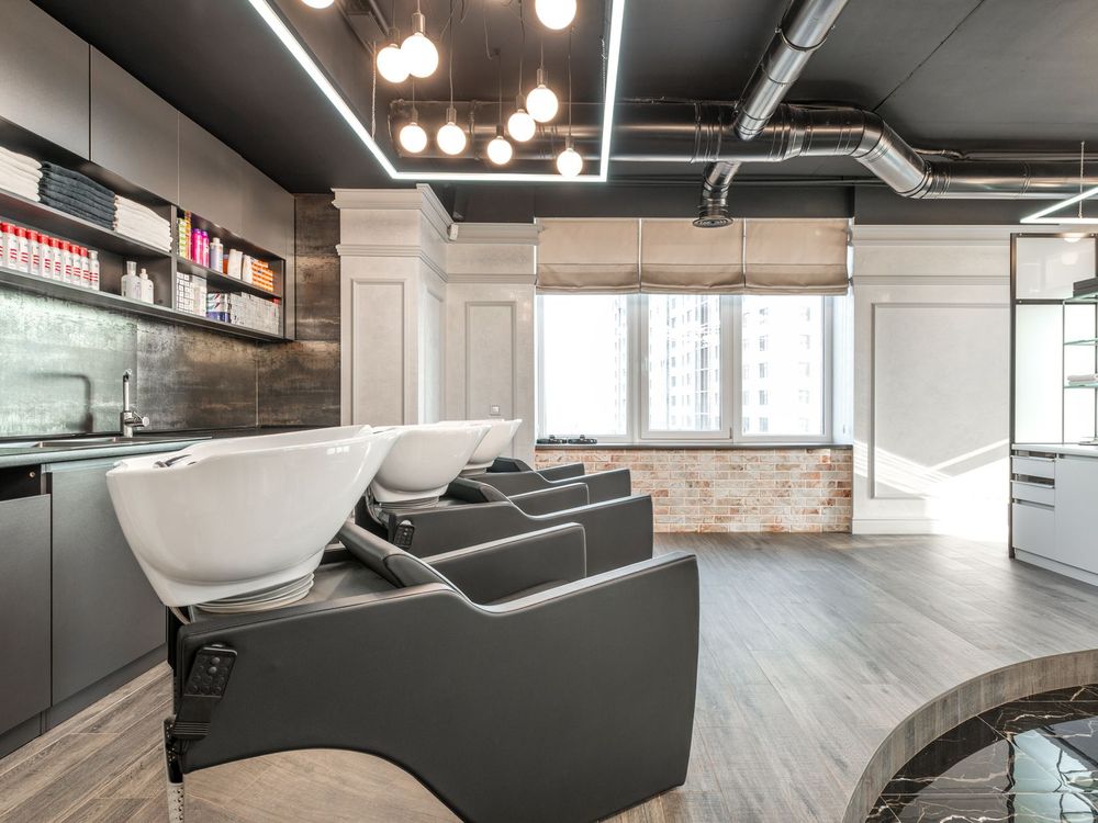 Salón de peluquería con tres puestos de lavacabezas y espejos
