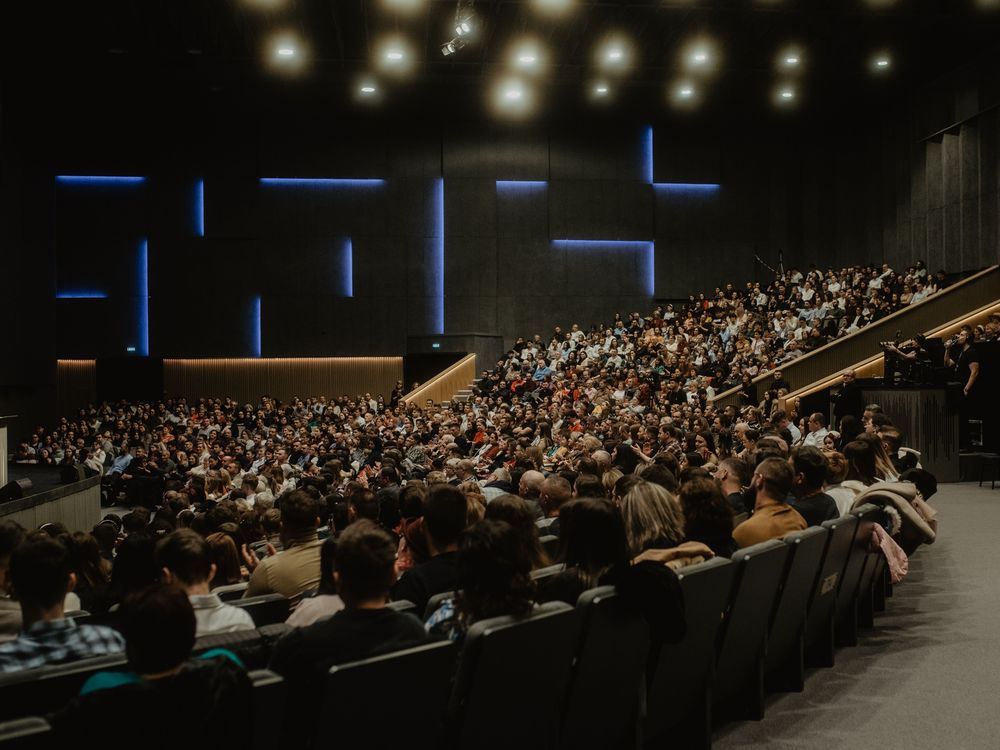 Congreso en auditorio con ponente y sala llena