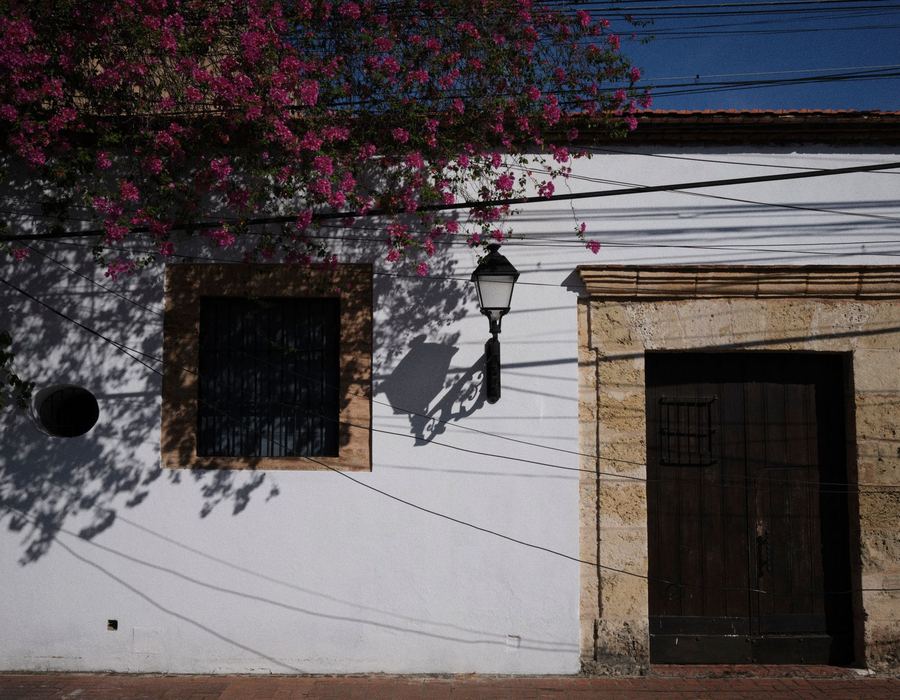A colonial facade in Santo Domingo covered in bright bougainvillea
