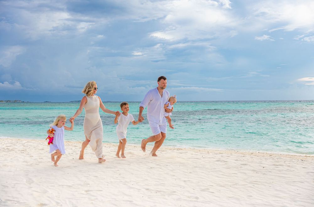 A family walking along a tropical beach at sunset