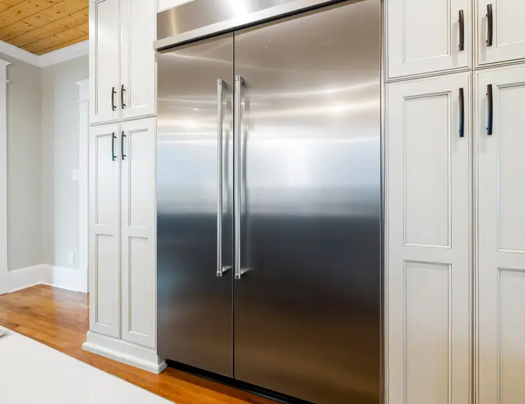 Nevera empotrada de acero inoxidable de dos puertas en una cocina blanca