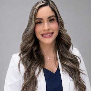 La Dra. Alexandra Estepan, especialista en gastroenterología, sonriendo con su bata blanca