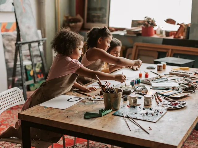 Young children painting together at a craft table