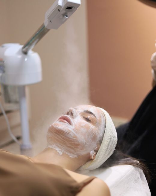 Esteticista con guantes haciendo una extracción en el rostro de una clienta