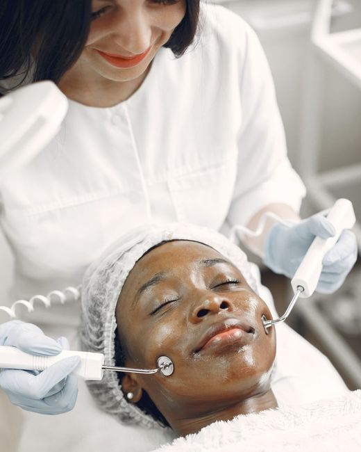 Clienta recibiendo un tratamiento facial con dos cabezales metálicos