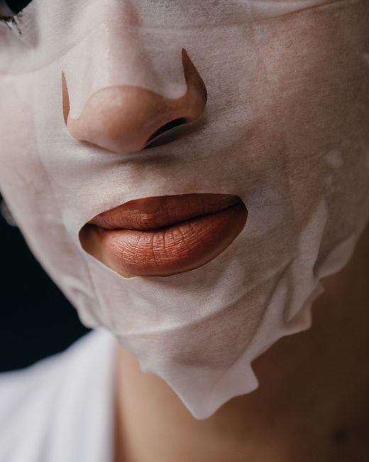 Mascarilla de tela blanca aplicada sobre el rostro de una clienta