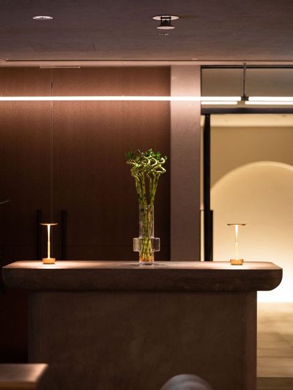 Recepción del centro con luz cálida, flores frescas y lámparas bajas
