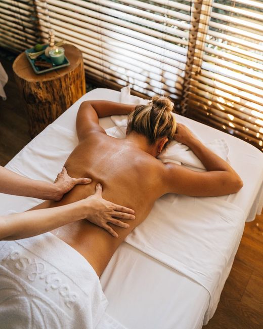 Masaje de espalda con aceite en una cabina con luz natural