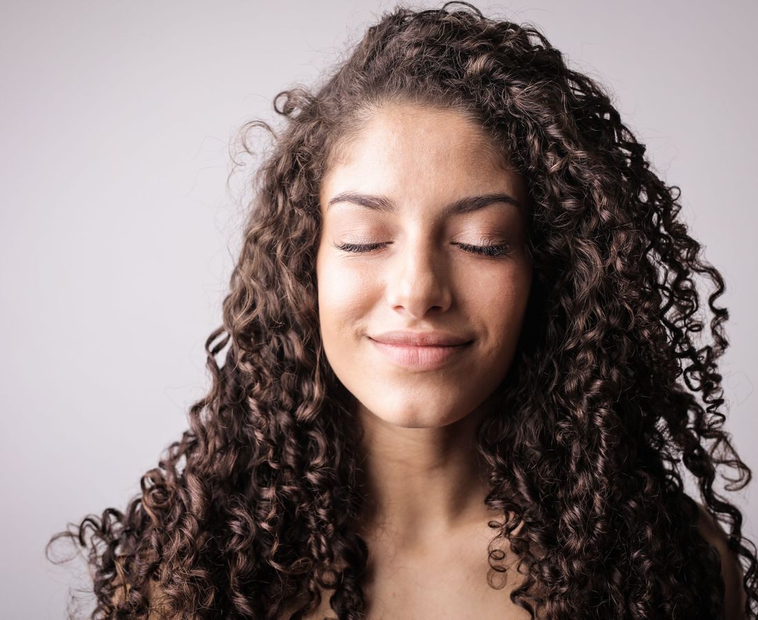 Mujer con el cabello rizado suelto, definido y con brillo