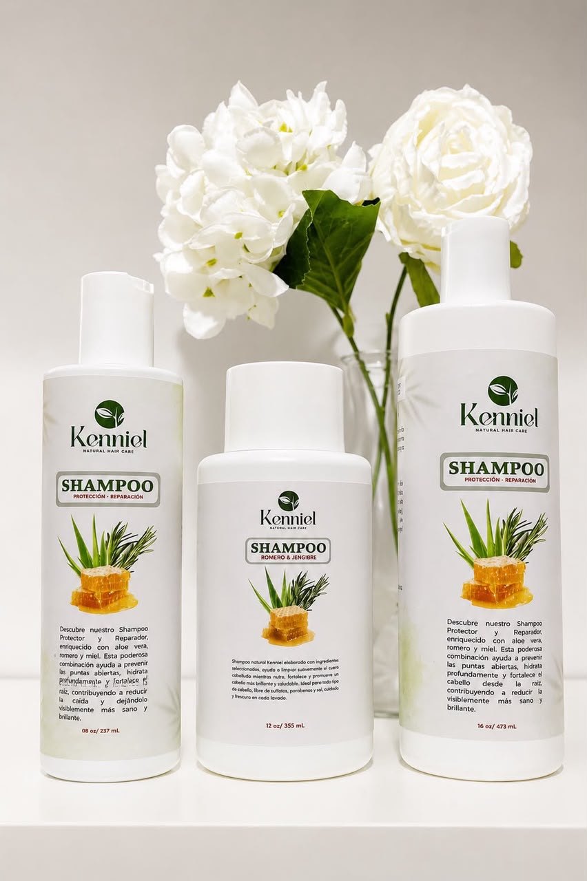 Los tres tamaños del shampoo Kenniel, de 8, 12 y 16 onzas, junto a un jarrón con flores blancas