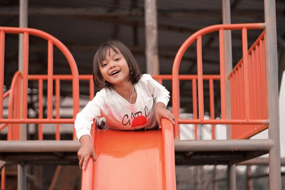 Niña sonriendo en un parque infantil