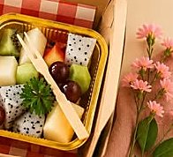 Vasito de frutas variadas con tenedor de madera