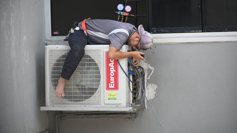 Técnico reparando una unidad de aire acondicionado